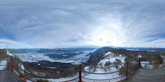 Großer Penegal mit Blick auf das Hotel Penegal, das Südtiroler Unterland mit demn Dolomiten dahinter und dem Nonstal mit der Brentagruppe im Hintergrund.