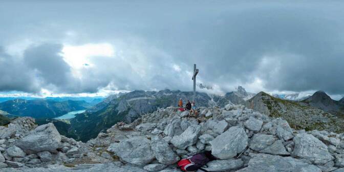 Am Gipfel des Croz dell'Altissimo. Blick auf den Molveno See und die in einer Wolkendecke verhüllten Berggipfel der Brenta Dolomiten.