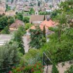 Im Vordergrund ein Teil der Guntschnapromenade, dann die Alte Grieser Pfarrkirche, dahinter breitet sich Bozen aus, Bolzano, Botanischer Garten, Bozen, Gotteshaus, Gries, Guntschnapromenade, Kirche, Landeshauptstadt Südtirol, Promenade, Spazierweg, Stadt, chiesa, church
