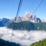 Blick auf die Sextner Dolomiten aus der Helmbahn, Aufstiegsanlage, Berg, Berge, Berglandschaft, Cima Dodici, Cima Nove, Cima Tre Scarperi, Cima Tre Scarpieri, Cima Una, Cima Undici, Croda Fiscialina, Croda Rossa di Sesto, Croda dei Toni, Dreischusterplatte, Dreischusterspitze, Einser, Einserkofel, Elfer, Elferkofel, Gebirge, Gebirgslandschaft, Gsell, Helmbahn, Hochbrunnerschneide, Kabinenbahn, Kabinenumlaufbahn, Lastron dei Scarperi, Monte Casella, Monte Popèra, Nebel, Nebelbank, Neuner, Neunerkofel, Oberbachernspitze, Schusterplatte, Seilbahn, Sextner Rotwand, Zehner, Zwölfer, Zwölferkofel