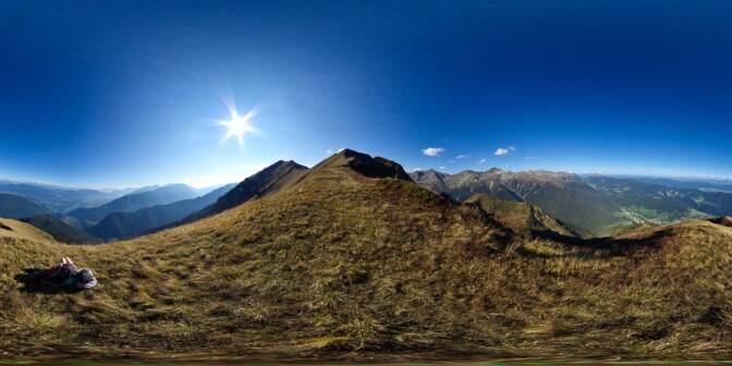 Abstieg querfeldein vom Monte Pin. Blick auf den St. Giustina Stausee und auf Rumo im obersten Teil vom Val di Non.