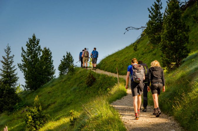 Wanderer in der Morgensonne am Fuße des Latemar