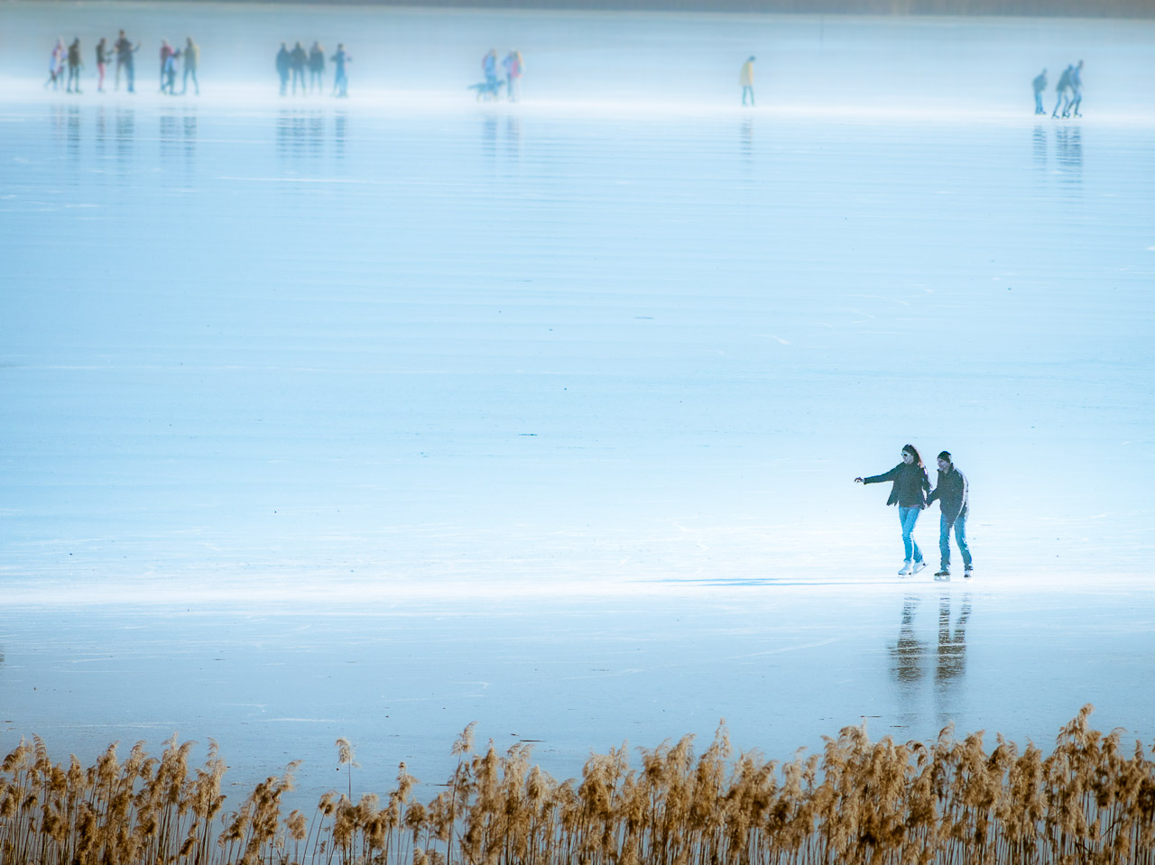 Schlittschuhläufer auf dem gefrorener Kalterer See