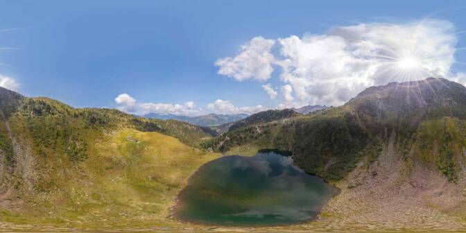 Lago di Moregna und Alm Moregna. In der Ferne die Dolomiten mit dem Latemar und der Rosengartengruppe