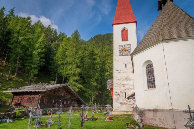 Pfarrkirche St. Gertraud mit Friedhof und dahinter das alte Schulgebäude