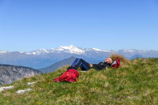 Rasten am Gipfel mit der Cima Presanella in den Adamello-Presanella-Alpen im Hintergrund