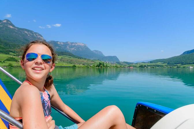 Anna, im Hintergrund die Lido Betriebe von St. Josef am See und in der Ferne das Dorf Kaltern.