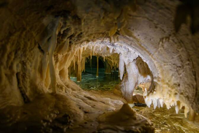 Blick durch das „Haifischmaul“ auf das Sinterbecken in der Kleinen Grotte