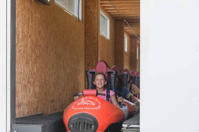 Anna voller Vorfreude im Bob der Sommerrodelbahn „Kaiserburg Rollbobbahn”
